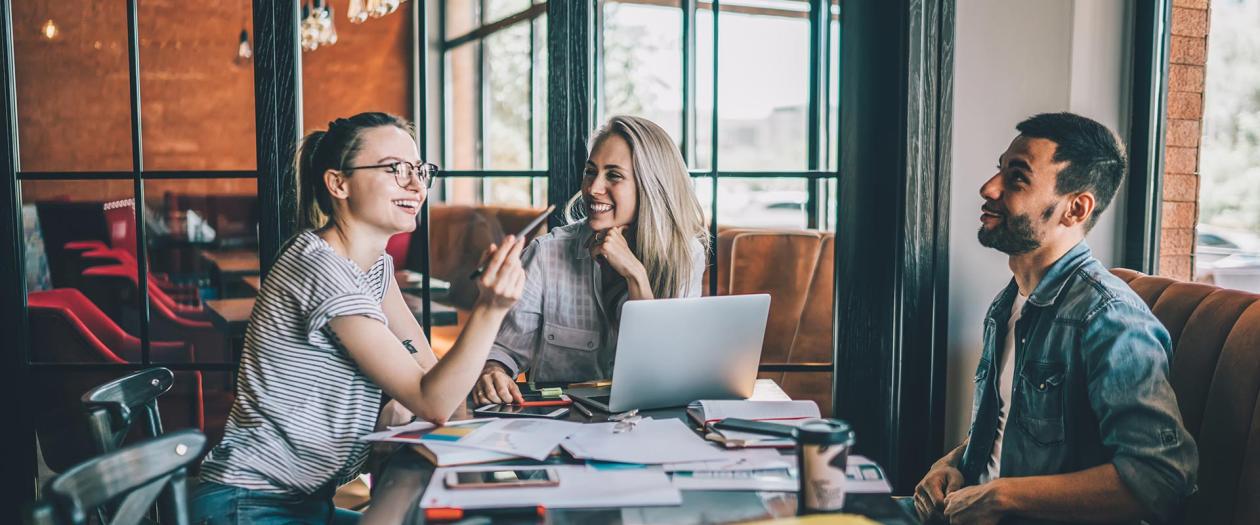 three college-aged students studying in cafe